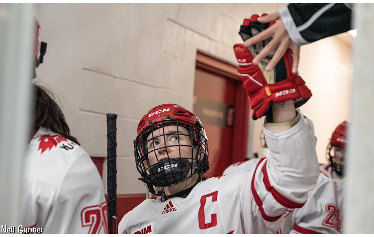 Hockey Image 9: Team Captain Brooke Anderson high fives a young fan on the way to the ice