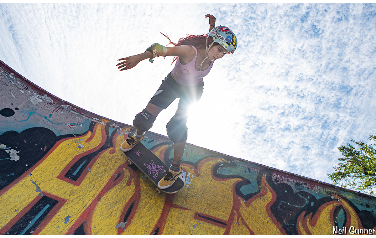 Sharlene hits the top of the vertical wall, sun peeking from behind